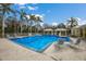 Community pool surrounded by palm trees and lounge chairs at 5684 Duval St, Bradenton, FL 34203