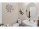 Charming powder room features stylish decor, toilet, and pedestal sink with round mirror at 5684 Duval St, Bradenton, FL 34203