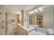 Bright bathroom features double sinks, spacious vanity, a walk-in shower with safety bars, and access to closet at 5780 Midnight Pass Rd # 303B, Sarasota, FL 34242