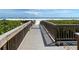 Scenic beach access boardwalk leading to white sand and crystal clear water, perfect for a relaxing beach day at 5780 Midnight Pass Rd # 303B, Sarasota, FL 34242