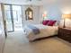 Bright bedroom with a sliding glass door, balcony access, carpet, and a comfortable king-size bed at 5780 Midnight Pass Rd # 303B, Sarasota, FL 34242
