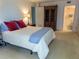 Bright bedroom featuring carpet, king size bed, decorative lamps, and a bathroom through the open door at 5780 Midnight Pass Rd # 303B, Sarasota, FL 34242