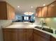 Modern kitchen featuring light countertops, stainless steel sink, wooden cabinets with a view to the dining area at 5780 Midnight Pass Rd # 303B, Sarasota, FL 34242