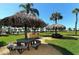 Outdoor kitchen and picnic area with tiki umbrellas, stainless steel grill, and ample green space perfect for entertaining at 5780 Midnight Pass Rd # 303B, Sarasota, FL 34242