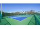 Outdoor pickleball courts with green and blue surfaces surrounded by lush landscaping at 5780 Midnight Pass Rd # 303B, Sarasota, FL 34242