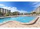 Community pool surrounded by lounge chairs and lush landscaping with a fountain in the background at 5780 Midnight Pass Rd # 303B, Sarasota, FL 34242