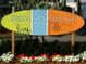 Charming Siesta Key Village sign surrounded by vibrant flowers, enhancing the area's welcoming and colorful appeal at 5780 Midnight Pass Rd # 303B, Sarasota, FL 34242