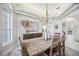 Bright dining room featuring a wooden table, modern chandelier, and neutral decor at 6626 The Masters Ave, Lakewood Ranch, FL 34202