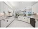 Bright open concept kitchen with white cabinetry, an island with seating, and stainless steel appliances at 6626 The Masters Ave, Lakewood Ranch, FL 34202