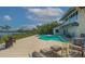 Backyard with a pool, deck, lounge chairs, and lush greenery overlooking the bay at 741 Hideaway Bay Dr, Longboat Key, FL 34228