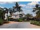 Beautifully landscaped home with tropical plants and a metal roof, set against a cloudy sky at 741 Hideaway Bay Dr, Longboat Key, FL 34228