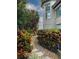 Lush landscaping with colorful plants, a stone path, and a glimpse of the home's architecture at 741 Hideaway Bay Dr, Longboat Key, FL 34228