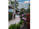 Beautiful landscaping with a brick path, blooming hibiscus, and lush greenery around the home at 741 Hideaway Bay Dr, Longboat Key, FL 34228
