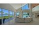 Bright living room features floor-to-ceiling windows with ocean views, a fireplace, and modern decor at 741 Hideaway Bay Dr, Longboat Key, FL 34228