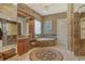 A large bathroom featuring a jacuzzi-style tub and spacious walk-in shower, all finished with marble tiling at 1007 3Rd E St, Palmetto, FL 34221