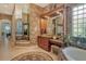 A large bathroom with dual vanities, a jacuzzi-style tub, and a comfortable seating area at 1007 3Rd E St, Palmetto, FL 34221