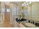 Bathroom featuring palm-themed wallpaper, a vanity, and a step-in shower with beige tiling at 1007 3Rd E St, Palmetto, FL 34221