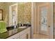 Bathroom with a granite countertop, vintage wallpaper, and a doorway leading to the outside at 1007 3Rd E St, Palmetto, FL 34221
