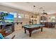 A carpeted game room features a pool table and TV, with a bar area visible in the background at 1007 3Rd E St, Palmetto, FL 34221