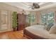 Bedroom with wood floors, a ceiling fan, and large windows with plantation shutters at 1007 3Rd E St, Palmetto, FL 34221
