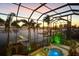 Covered pool and spa with palm trees overlooking the waterway at 1007 3Rd E St, Palmetto, FL 34221