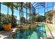 A stunning screened-in pool area with a spa, tropical plants, and waterfront views at 1007 3Rd E St, Palmetto, FL 34221