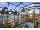 Stunning screened-in pool area with spa, lush landscaping, and waterfront views at 1007 3Rd E St, Palmetto, FL 34221