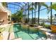 A luxurious pool area within a screened enclosure, with a spa and a picturesque waterfront backdrop at 1007 3Rd E St, Palmetto, FL 34221