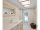 Well-lit bathroom with a sleek vanity, a large mirror, and a doorway to an outdoor area at 1612 Pine Harrier Cir, Sarasota, FL 34231