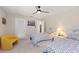 Cozy bedroom featuring twin beds with patterned bedding, a ceiling fan, and a yellow accent chair at 1612 Pine Harrier Cir, Sarasota, FL 34231