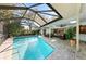 Beautiful screened-in pool with comfortable seating and lush landscaping at 1612 Pine Harrier Cir, Sarasota, FL 34231