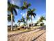 Attractive community entrance with lush palm trees, a decorative fountain, and a paved brick driveway at 2001 Bal Harbor Blvd # 2301, Punta Gorda, FL 33950