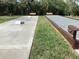 Outdoor bocce ball court featuring benches, well maintained grass, and lush landscaping at 25188 Marion Ave # E208, Punta Gorda, FL 33950