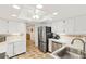 Well-lit kitchen with white cabinets, stainless steel appliances, and checkerboard tile flooring with views to other rooms at 25188 Marion Ave # E208, Punta Gorda, FL 33950