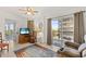 Cozy room with a recliner, ceiling fan, a TV, and sliding doors to a balcony at 25188 Marion Ave # E208, Punta Gorda, FL 33950