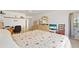 Bright main bedroom featuring a floral bedspread, desk, and balcony access at 25188 Marion Ave # E208, Punta Gorda, FL 33950