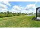 Expansive backyard featuring lush grass, a picturesque pond, and a peaceful wooded area at 309 Potenza Loop, Nokomis, FL 34275