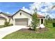 Charming single-story home with a well-manicured lawn and a two-car garage and a red tile roof at 309 Potenza Loop, Nokomis, FL 34275