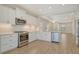 Well-lit kitchen with white cabinets, stainless steel appliances and wood-look tile flooring at 309 Potenza Loop, Nokomis, FL 34275