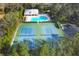 Aerial view of community amenities including tennis courts and a large swimming pool at 3301 River Woods Dr, Parrish, FL 34219