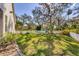 Lush green backyard with a white picket fence, mature trees, and manicured lawn at 3301 River Woods Dr, Parrish, FL 34219