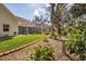Expansive backyard featuring a screened-in patio, lush lawn, mature trees and landscaped flower beds at 3301 River Woods Dr, Parrish, FL 34219