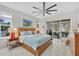 Bright bedroom features a slider to lanai, modern ceiling fan, and neutral decor at 3301 River Woods Dr, Parrish, FL 34219