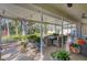 View of the covered patio with dining furniture and lush landscaping at 3301 River Woods Dr, Parrish, FL 34219