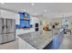 Modern kitchen featuring a large island, stainless steel appliances, and vibrant blue backsplash at 3301 River Woods Dr, Parrish, FL 34219
