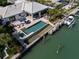 Aerial view of a waterfront home with a pool, spa, patio, and boat dock on a canal at 355 W Royal Flamingo Dr, Sarasota, FL 34236