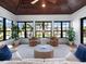 Cozy sunroom with two leather chairs, large windows, wood ceilings, and views of the tropical landscaping at 355 W Royal Flamingo Dr, Sarasota, FL 34236