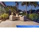 Outdoor living area with a modern fire pit and comfortable seating surrounded by lush tropical landscaping at 355 W Royal Flamingo Dr, Sarasota, FL 34236