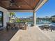Covered patio with an outdoor dining table, lounge chairs, and views of the pool and canal at 355 W Royal Flamingo Dr, Sarasota, FL 34236