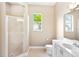 Bathroom with a glass shower, double vanity, and natural light from two windows at 4245 Corso Venetia Blvd, Venice, FL 34293